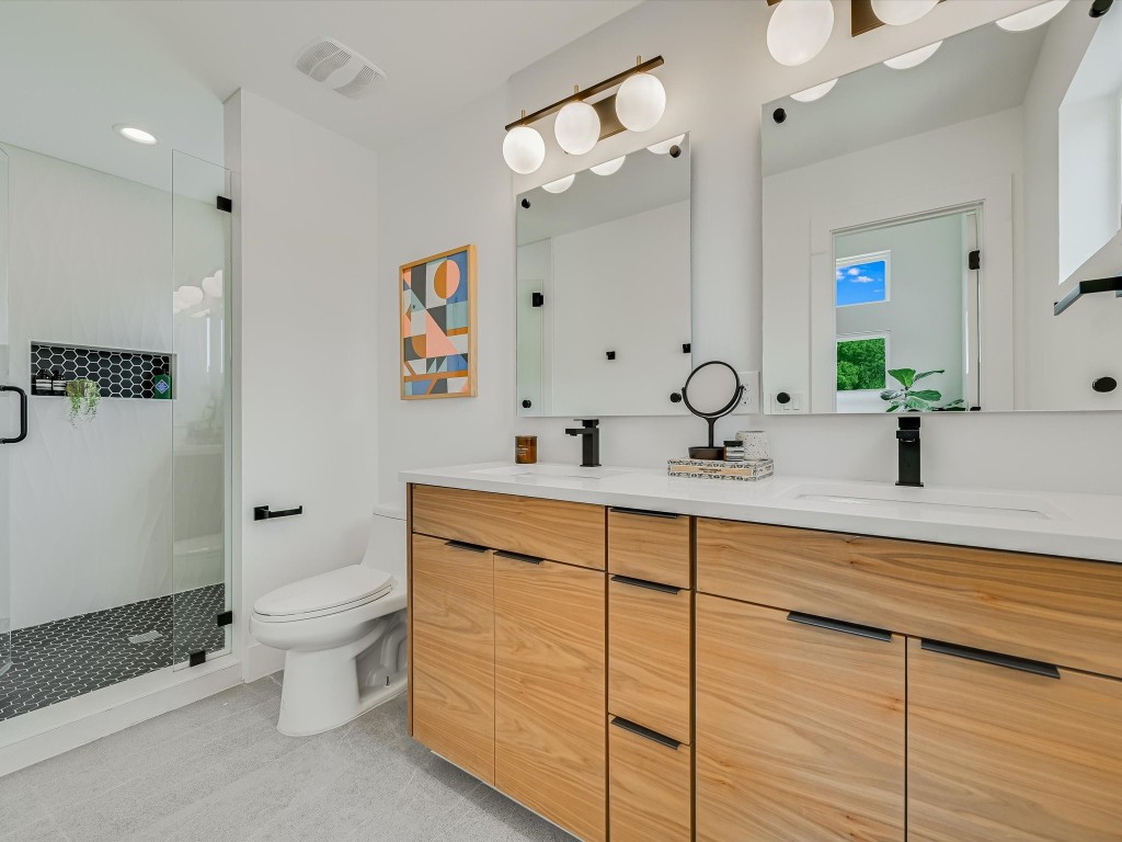 5603 Samuel Huston Avenue, Unit 1 Austin, TX 78721 - Photo 16 of 40 a bathroom with a double vanity sink mirror and toilet