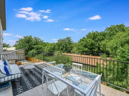 a view of a patio with table and chairs with wooden floor and fence