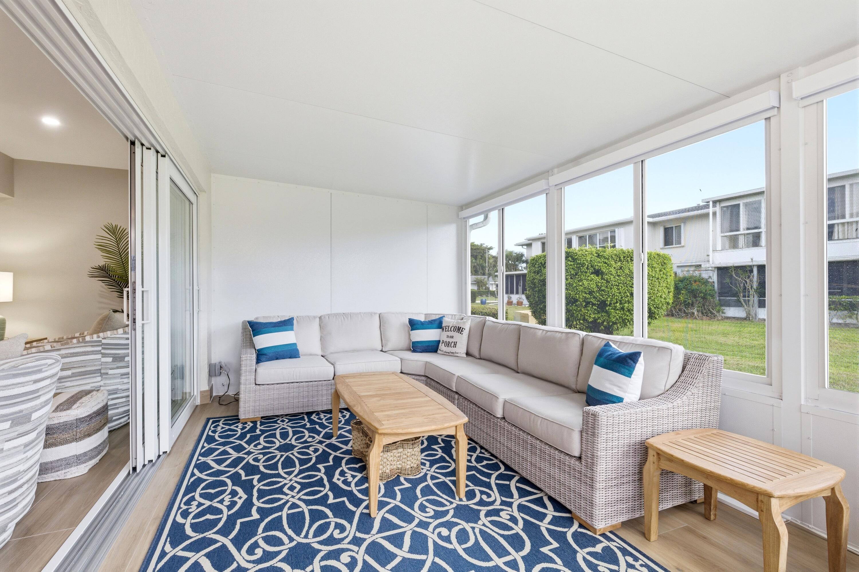 1415 Southwest 27th Avenue, Unit 104 Delray Beach, FL 33445 - Photo 18 of 43 a living room with furniture and a floor to ceiling window