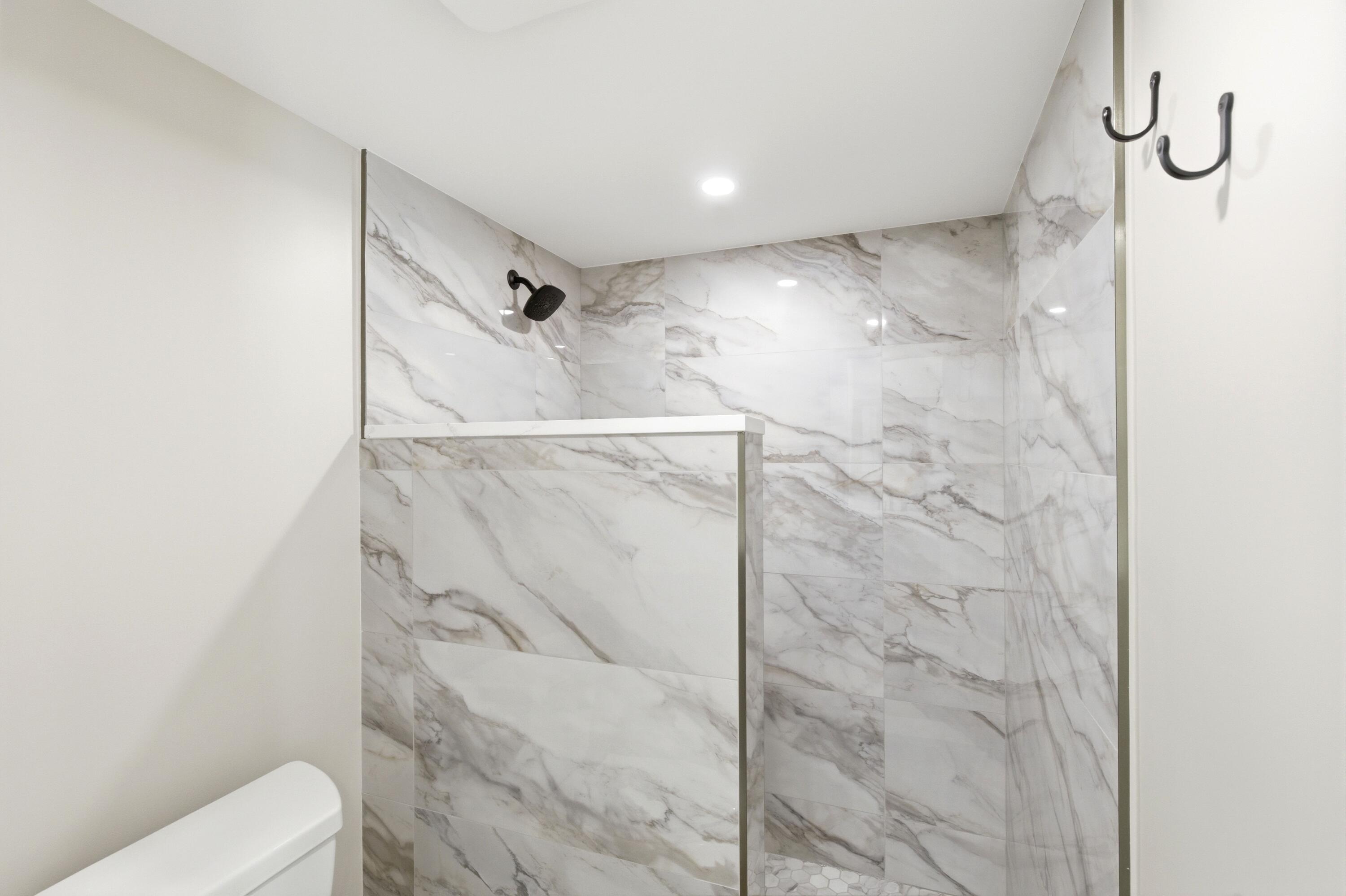 1415 Southwest 27th Avenue, Unit 104 Delray Beach, FL 33445 - Photo 26 of 43 a bathroom with a shower and a toilet