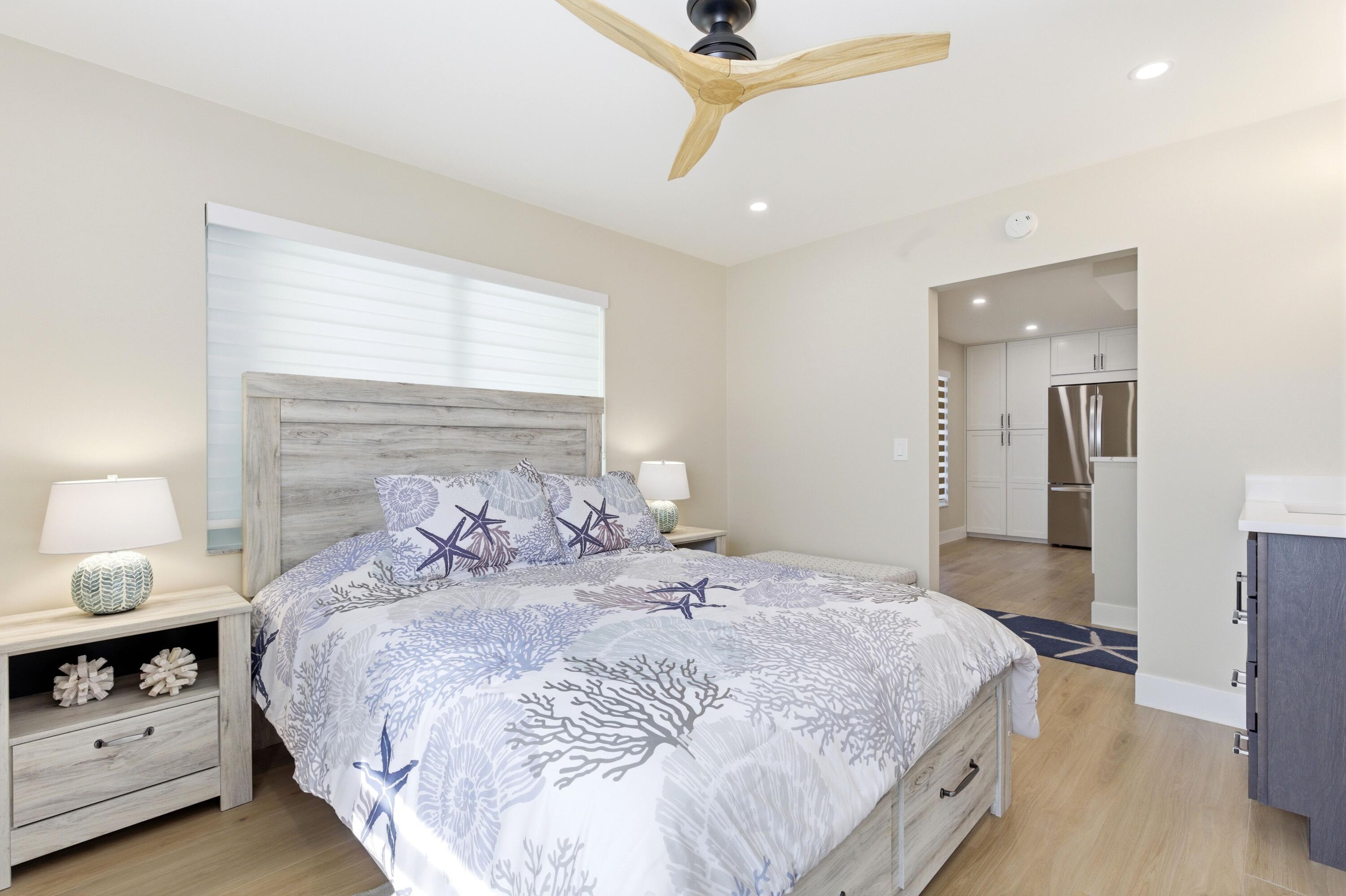 1415 Southwest 27th Avenue, Unit 104 Delray Beach, FL 33445 - Photo 29 of 43 a bedroom with a bed and a night stand