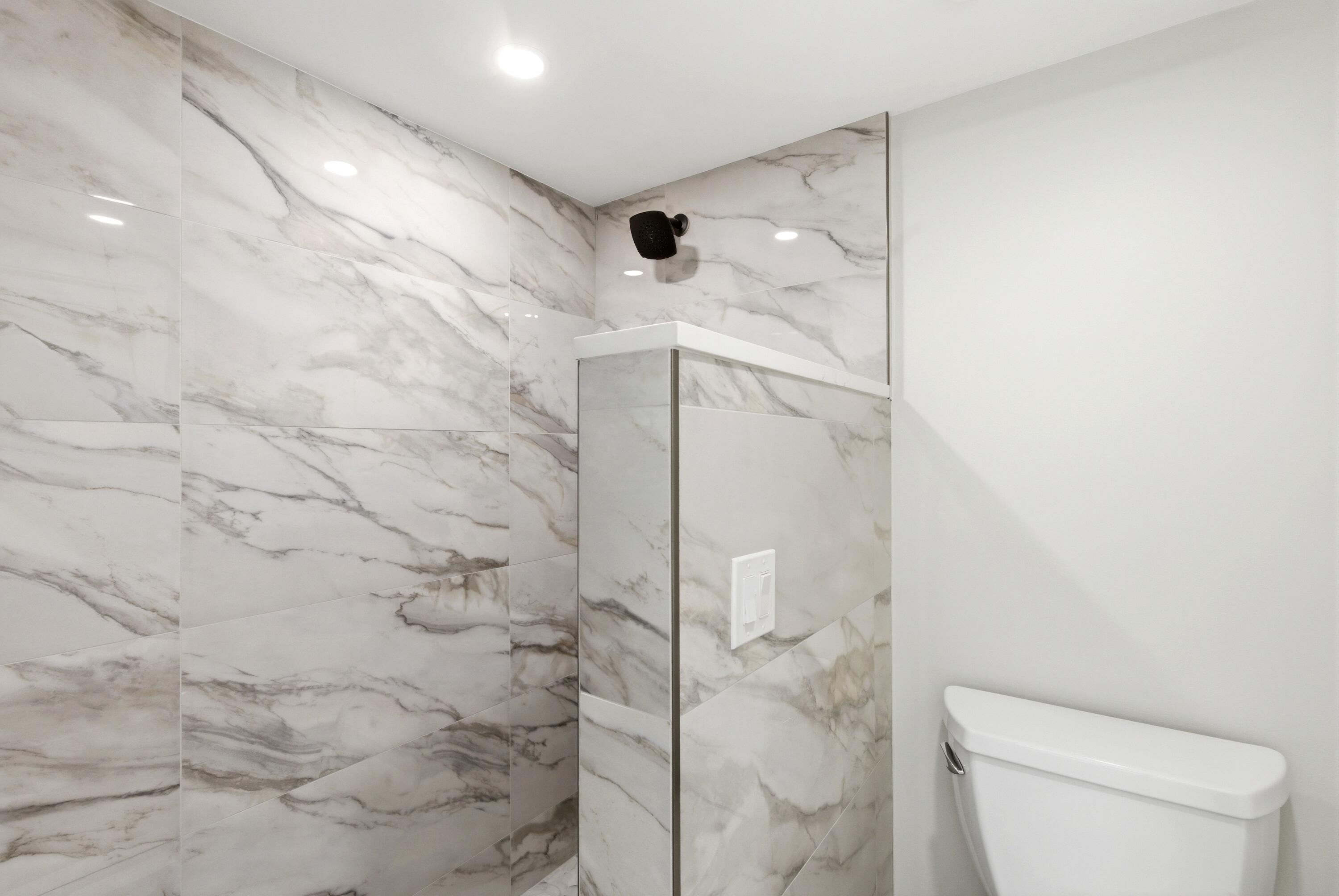 1415 Southwest 27th Avenue, Unit 104 Delray Beach, FL 33445 - Photo 32 of 43 a bathroom with a shower and toilet