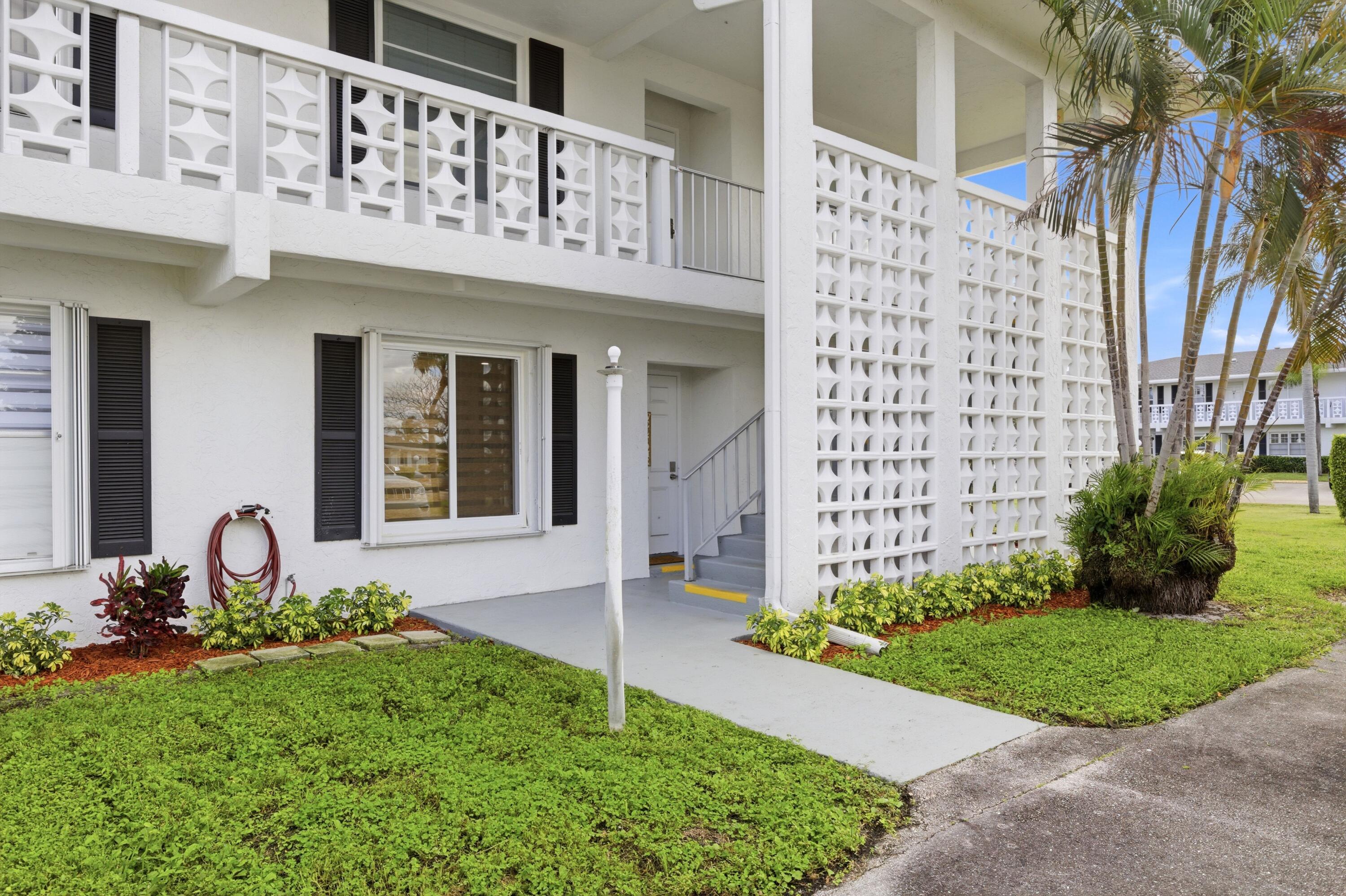 1415 Southwest 27th Avenue, Unit 104 Delray Beach, FL 33445 - Photo 43 of 43 a front view of a building with garden