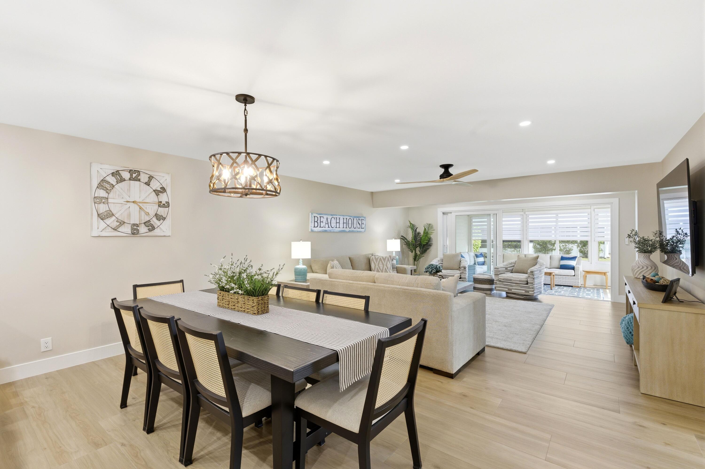 1415 Southwest 27th Avenue, Unit 104 Delray Beach, FL 33445 - Photo 8 of 43 a view of a dining room with furniture wooden floor and chandelier