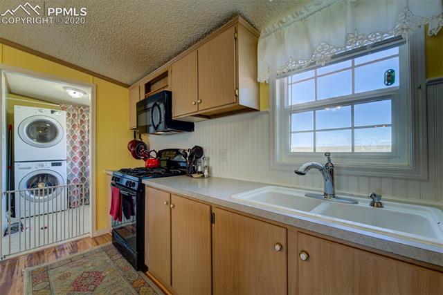 8050 Edison Road Yoder, CO 80864 - Photo 18 of 34 Laundry room, off kitchen. Also has a door to the backyard. View of Pikes Peak and range from kitchen window.
Small dog will be contained behind gate for showings