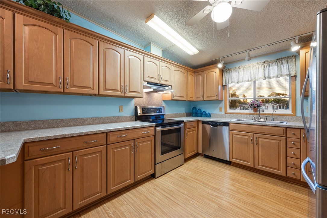 19658 Eagle Trace Court North Fort Myers, FL 33903 - Photo 15 of 40 a kitchen with granite countertop wooden cabinets a sink and dishwasher