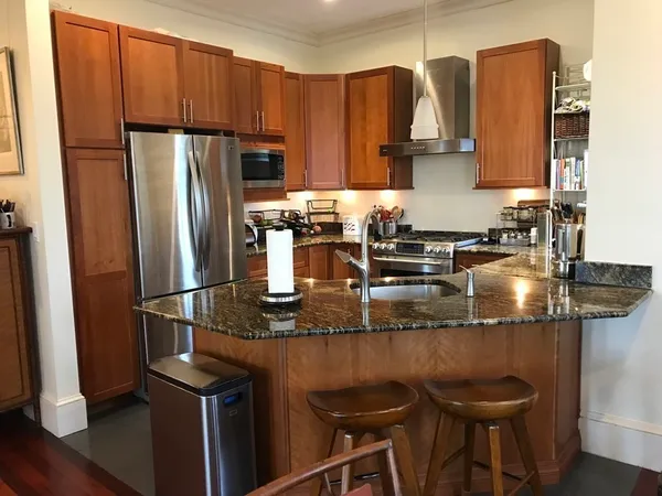 a kitchen with stainless steel appliances granite countertop a sink refrigerator and microwave