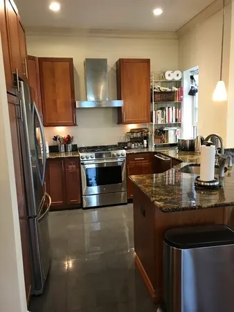 a kitchen with stainless steel appliances granite countertop a sink stove and refrigerator