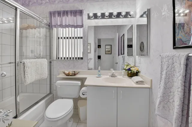 a bathroom with a sink toilet vanity and shower