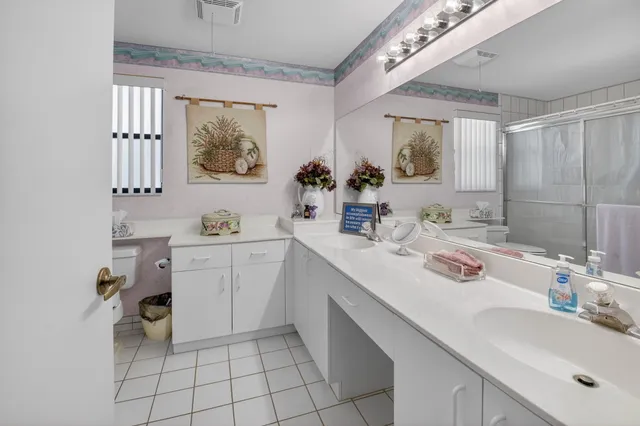 a bathroom with a double vanity sink mirror and toilet