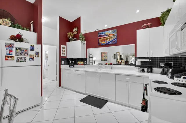 a kitchen with a sink a refrigerator and cabinets
