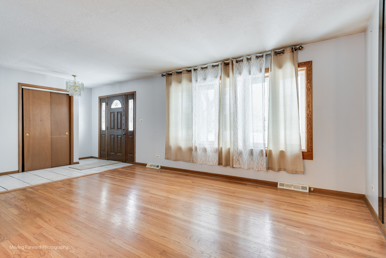 539 West Eggerding Drive Addison, IL 60101 - Photo 4 of 29 a view of an empty room with a window and wooden floor