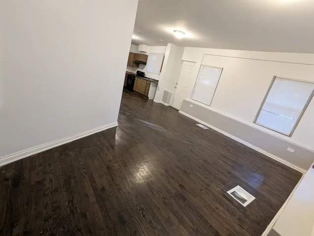 an empty room with wooden floor and stairs