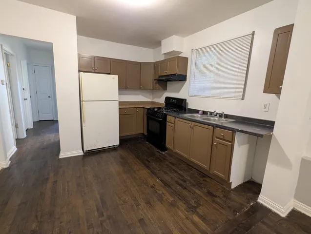 a kitchen with a sink a refrigerator and a stove top oven