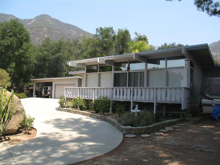 a view of a house with a yard and potted plants