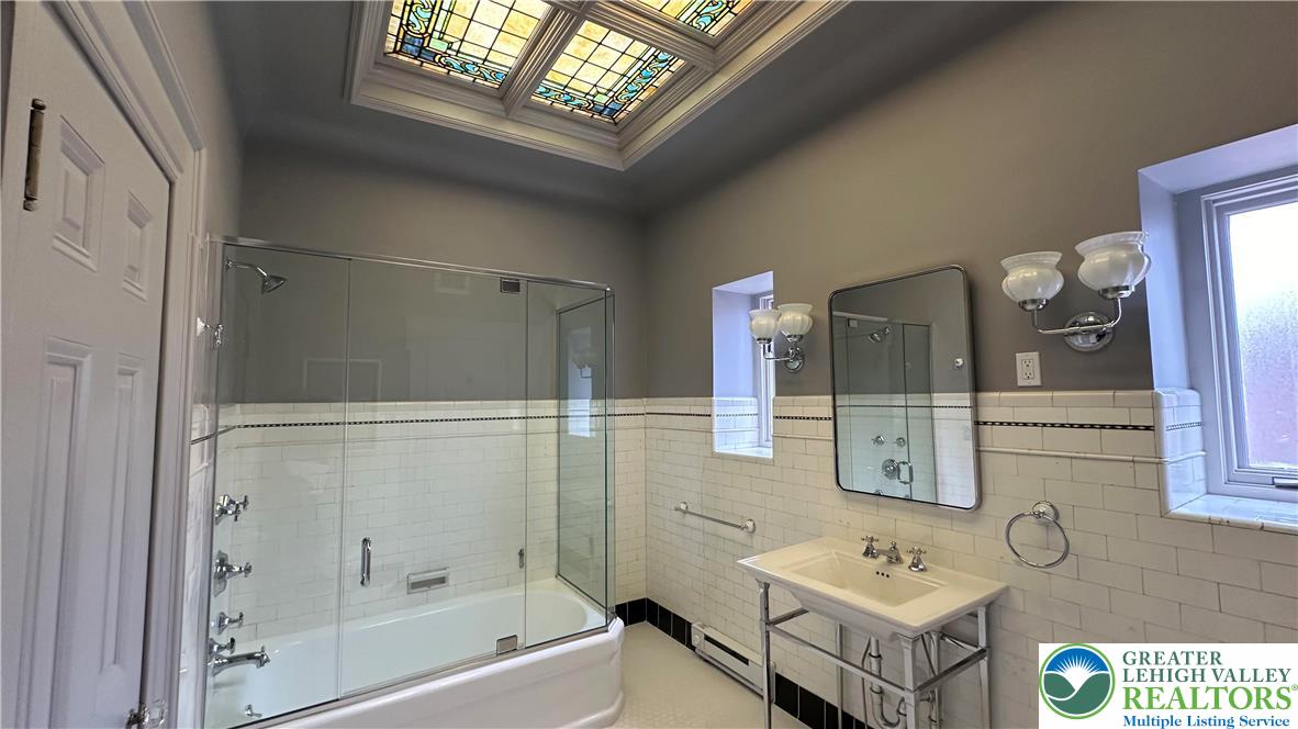 214 Spring Garden Street, Unit 3A Easton, PA 18042 - Photo 15 of 20 a bathroom with a tub sink and mirror