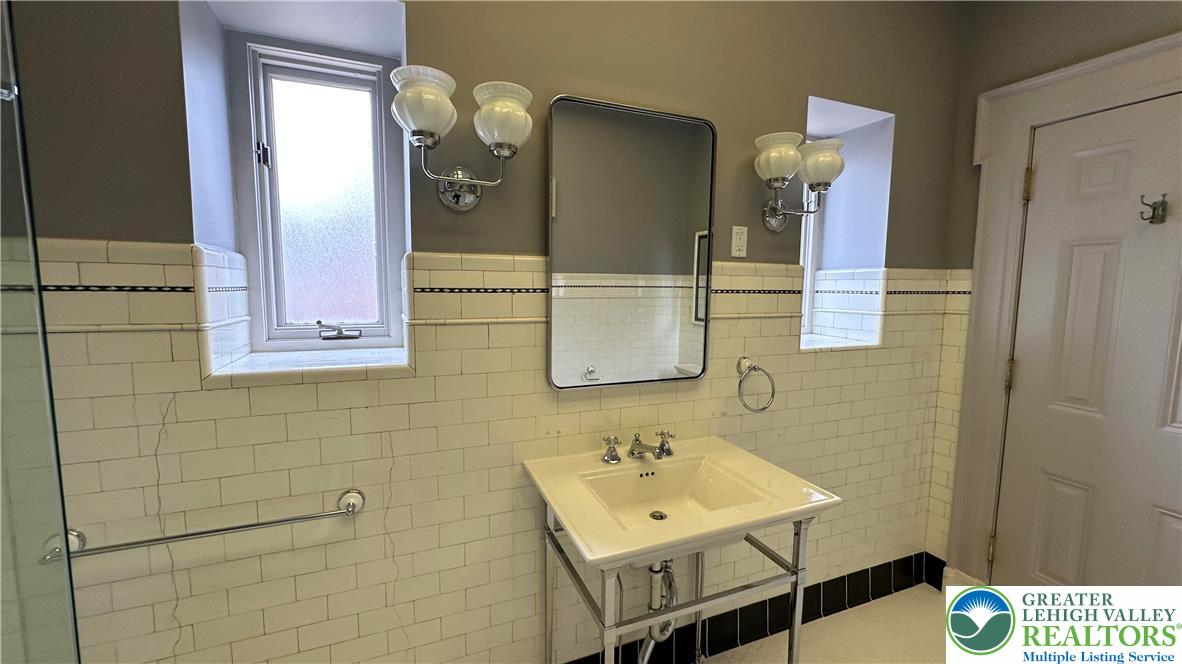 214 Spring Garden Street, Unit 3A Easton, PA 18042 - Photo 16 of 20 a bathroom with a sink a mirror and a shower