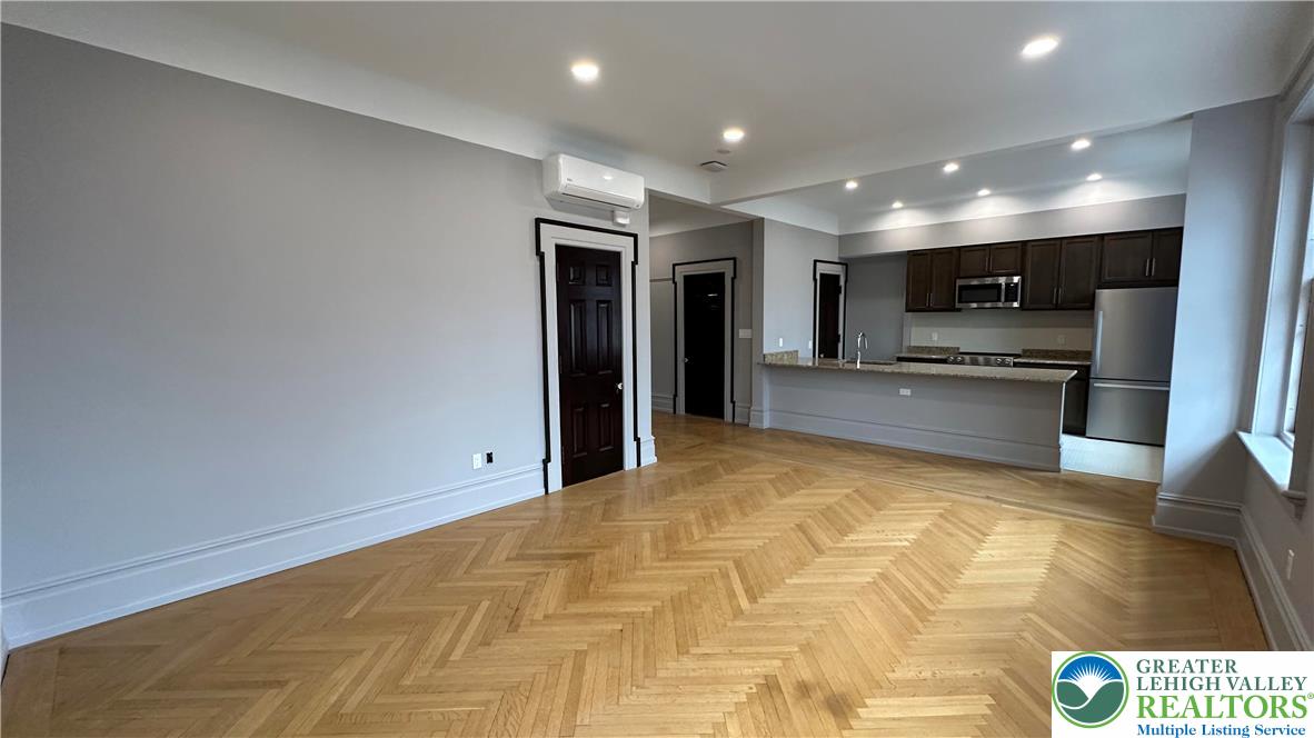 214 Spring Garden Street, Unit 3A Easton, PA 18042 - Photo 7 of 20 a view of kitchen with kitchen island granite countertop refrigerator and microwave