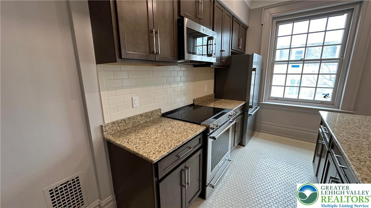 214 Spring Garden Street, Unit 3A Easton, PA 18042 - Photo 9 of 20 a kitchen with a sink stove and cabinets