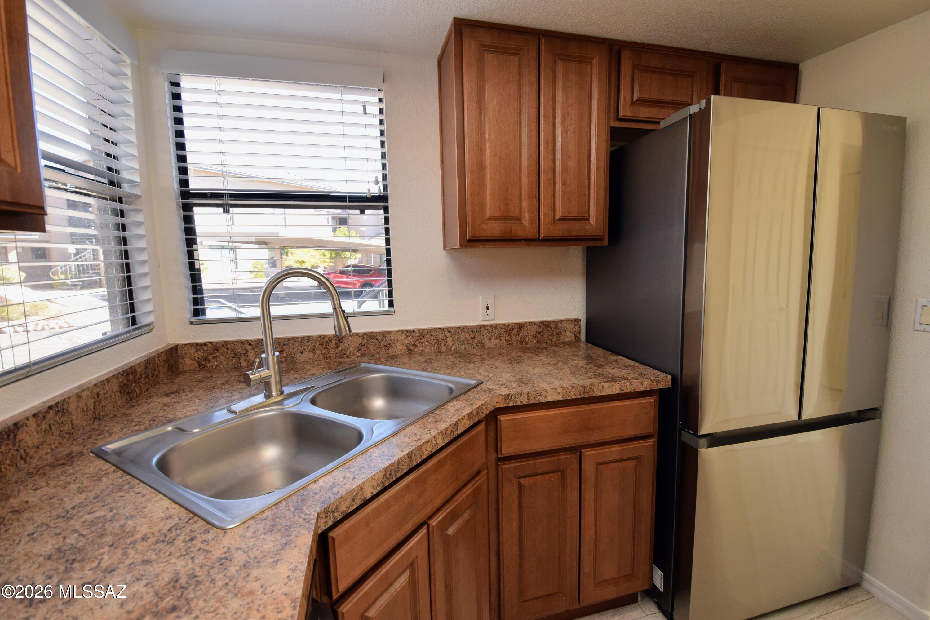 5855 North Kolb Road, Unit 11106 Tucson, AZ 85750 - Photo 14 of 36 a kitchen with stainless steel appliances granite countertop a refrigerator and a sink