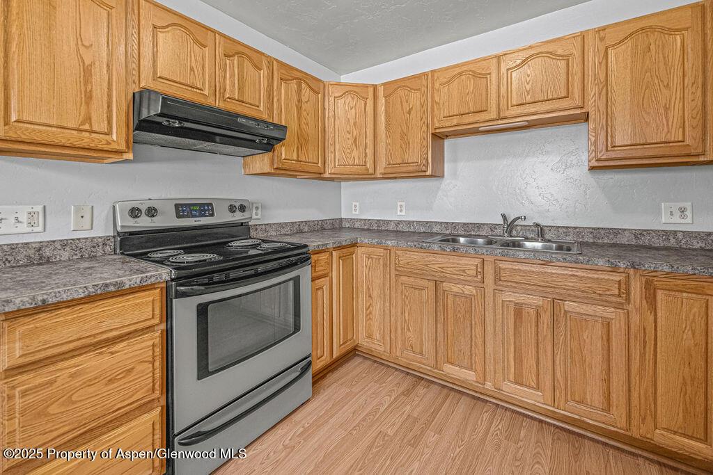 627 Lake Street Rangely, CO 81648 - Photo 5 of 44 a kitchen with stainless steel appliances granite countertop a sink a stove and cabinets