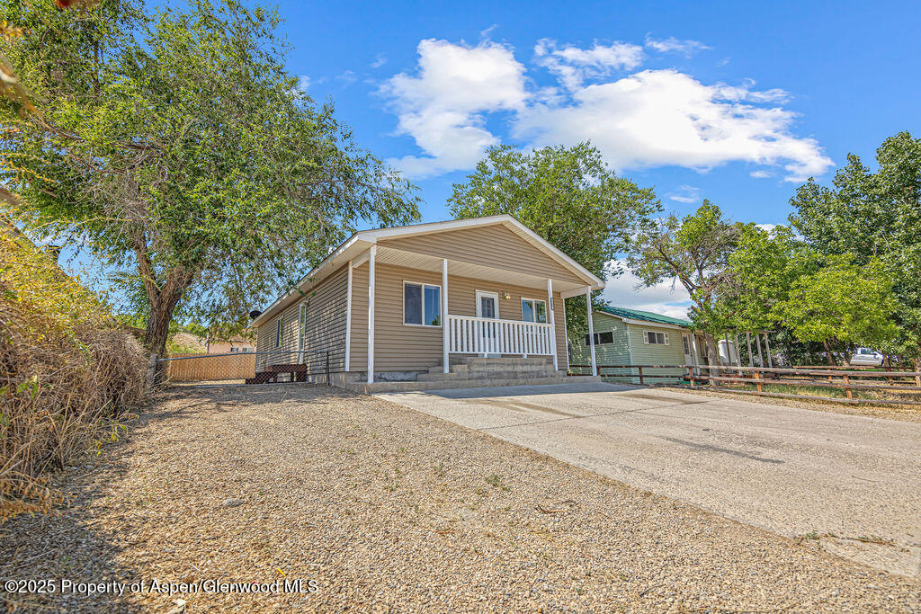 627 Lake Street Rangely, CO 81648 - Photo 9 of 44 a front view of a house with a yard and trees