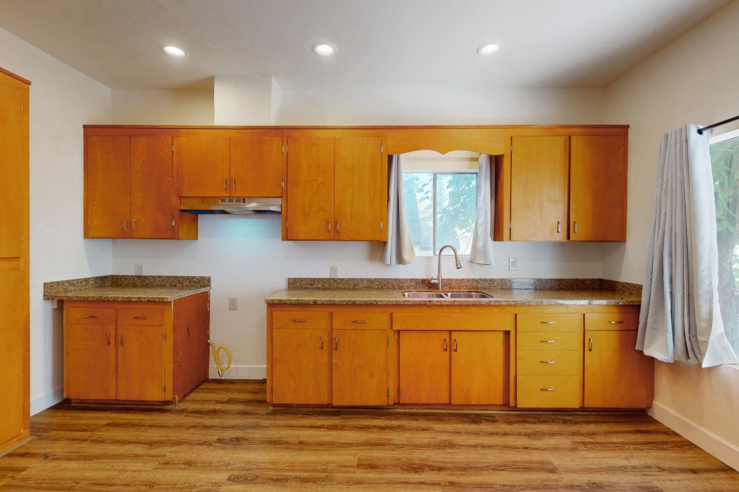 1585 Sycamore Street Gridley, CA 95948 - Photo 11 of 69 a large kitchen with stainless steel appliances granite countertop a sink a stove counter space and wooden floor