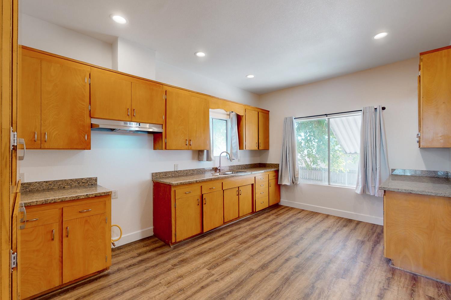 1585 Sycamore Street Gridley, CA 95948 - Photo 12 of 69 a kitchen with stainless steel appliances granite countertop a sink a stove a refrigerator with grey cabinets and wooden floor