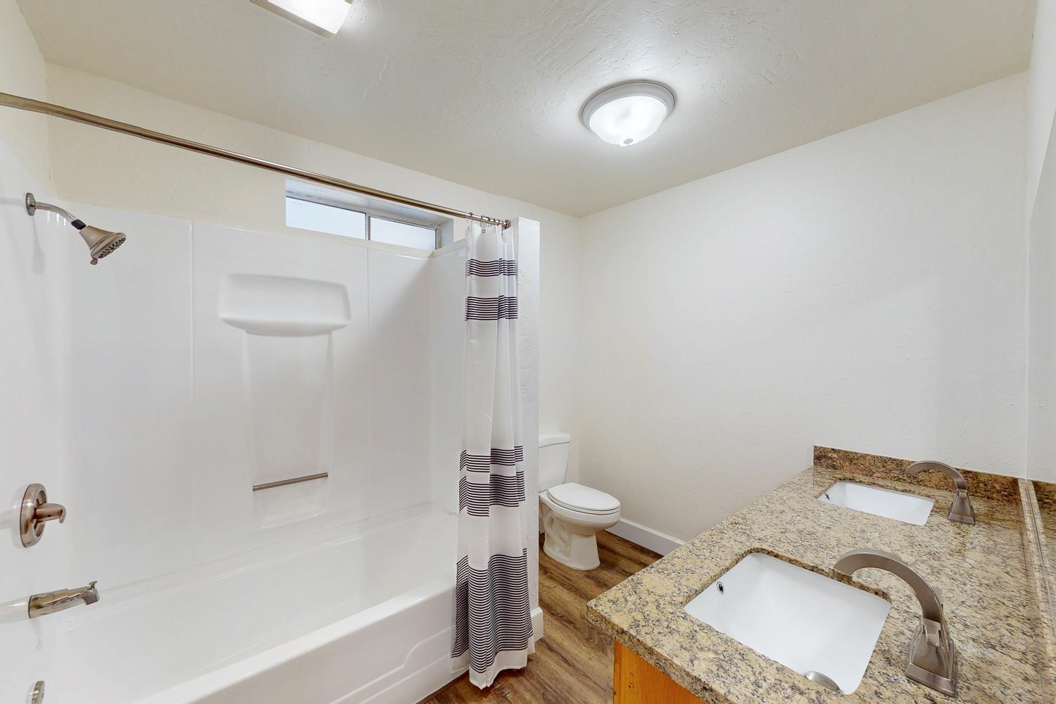 1585 Sycamore Street Gridley, CA 95948 - Photo 26 of 69 a bathroom with a granite countertop sink a toilet and bathtub