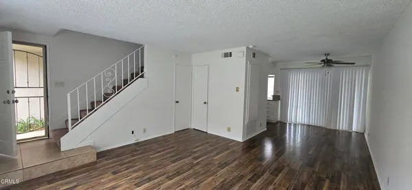 a view of a hallway with wooden floor and staircase