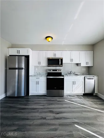 a kitchen with stainless steel appliances granite countertop a refrigerator sink and stove