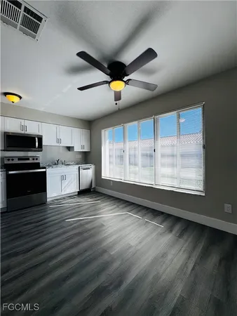 a large kitchen with stainless steel appliances granite countertop a stove and a wooden floors