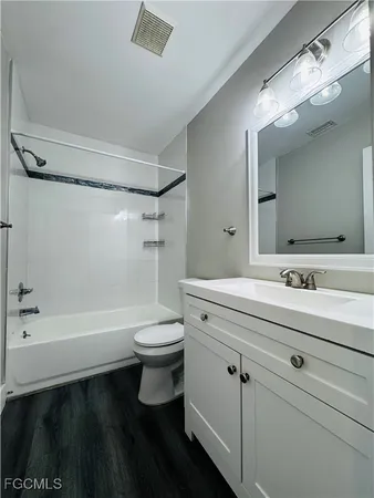 a bathroom with a sink a toilet a mirror a bathtub and shower