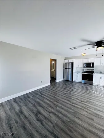 a view of a kitchen with wooden floor and an empty space