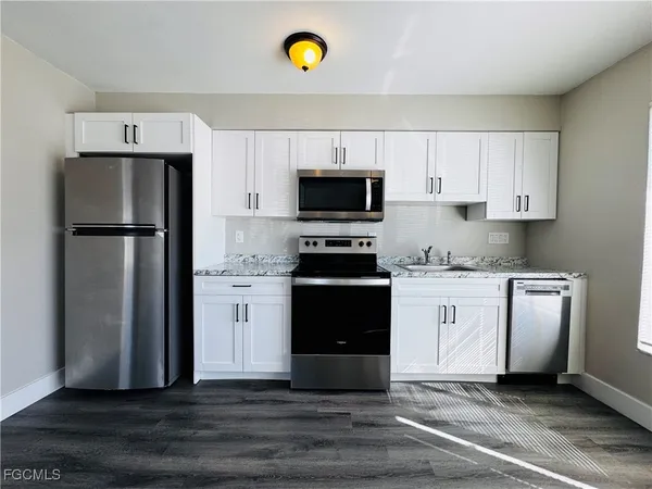 a kitchen with a refrigerator and a stove top oven