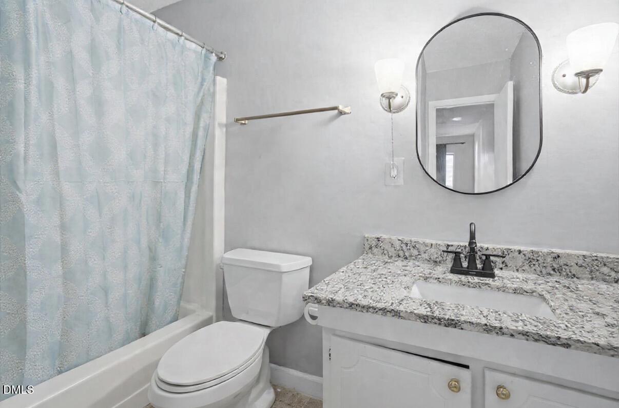 5130 Flint Ridge Place Raleigh, NC 27609 - Photo 19 of 22 a bathroom with a granite countertop sink a toilet and a mirror