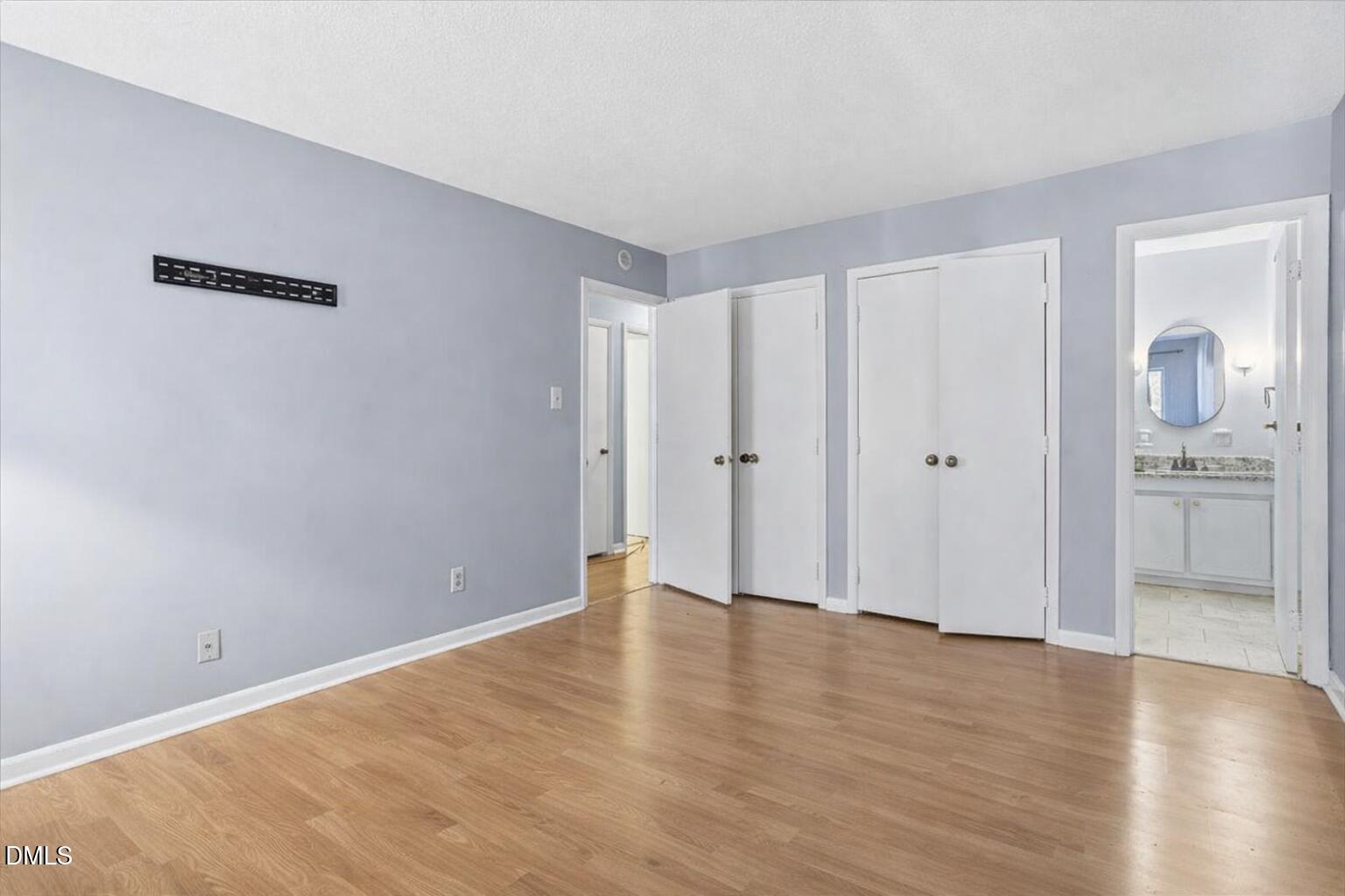 5130 Flint Ridge Place Raleigh, NC 27609 - Photo 21 of 22 a view of an empty room with wooden floor and a kitchen