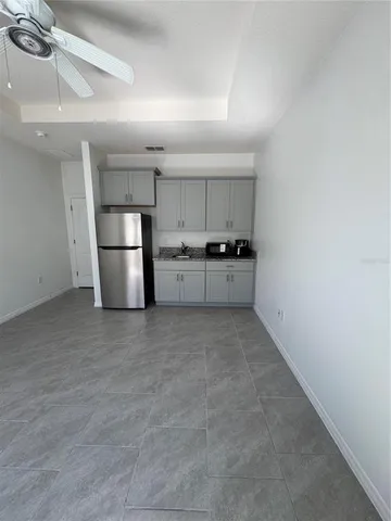 a view of a kitchen with a sink and refrigerator