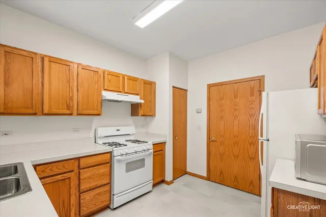 a kitchen with stainless steel appliances granite countertop a refrigerator and a stove top oven