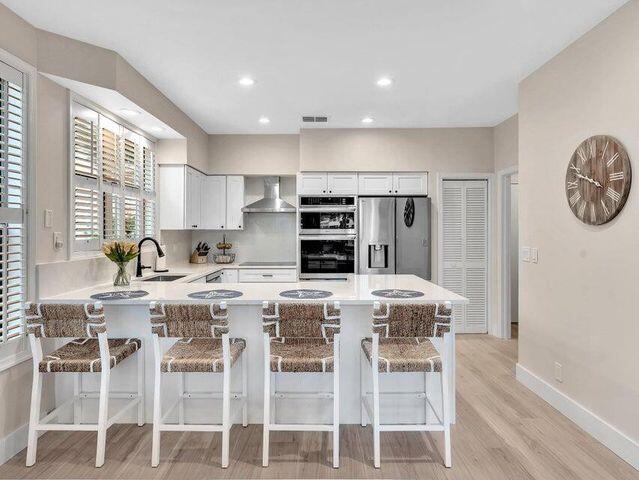 2237 Northwest 53rd Street Boca Raton, FL 33496 - Photo 14 of 76 a kitchen with a dining table cabinets appliances and a window