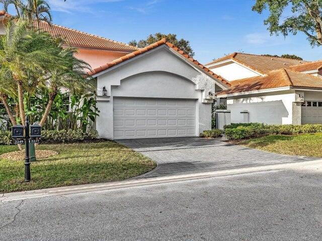 2237 Northwest 53rd Street Boca Raton, FL 33496 - Photo 51 of 76 a front view of a house with a yard and garage