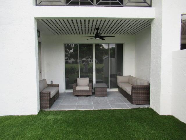 2237 Northwest 53rd Street Boca Raton, FL 33496 - Photo 56 of 76 a view of a patio with a table and chairs and a floor to ceiling window