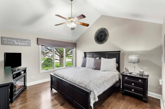 a bedroom with a bed and a flat tv screen on a dresser