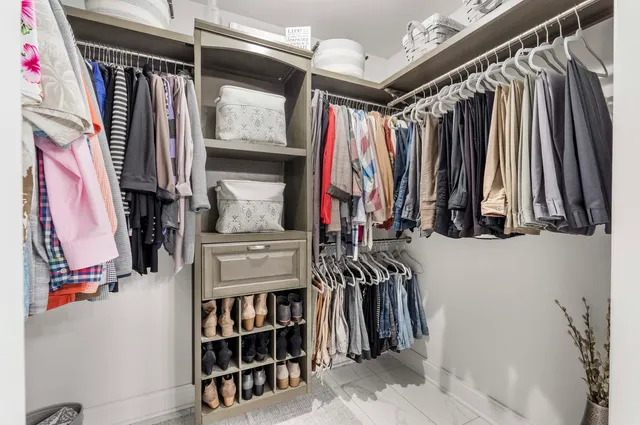a view of walk in closet with clothes and shoes