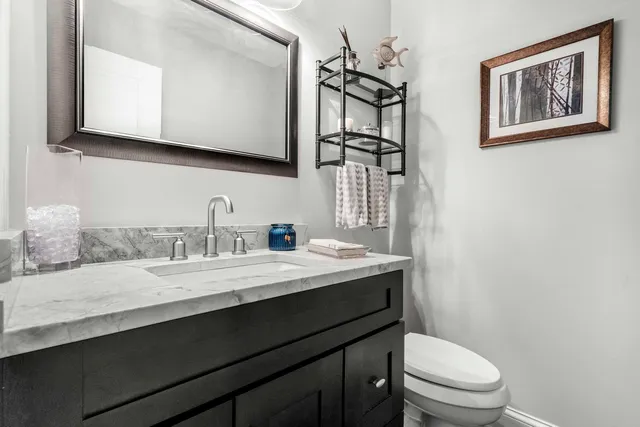a bathroom with a granite countertop sink mirror and toilet