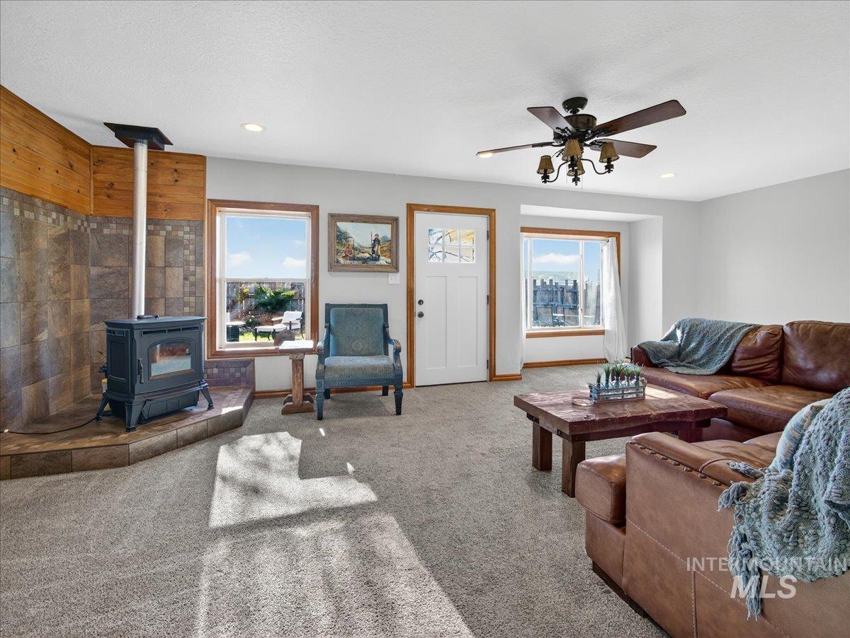 2588 West Sales Yard Road Emmett, ID 83617 - Photo 12 of 49 Living room featuring a wood stove, healthy amount of natural light, carpet, and recessed lighting