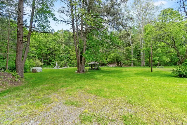 a view of a house with backyard and sitting area