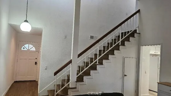 a view of staircase with railing and white walls