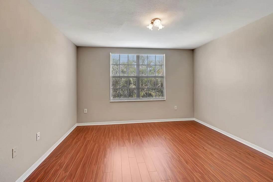 15155 Michelangelo Boulevard, Unit 306 Delray Beach, FL 33446 - Photo 14 of 32 an empty room with wooden floor and windows
