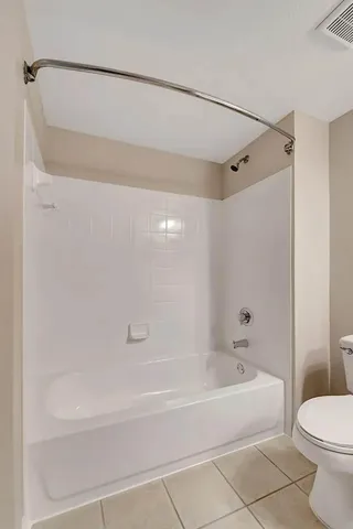 a bathroom with a bathtub shower sink mirror vanity and toilet